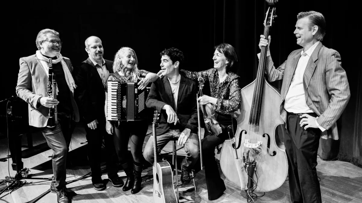The six Kleztory musicians posing on stage with their instruments